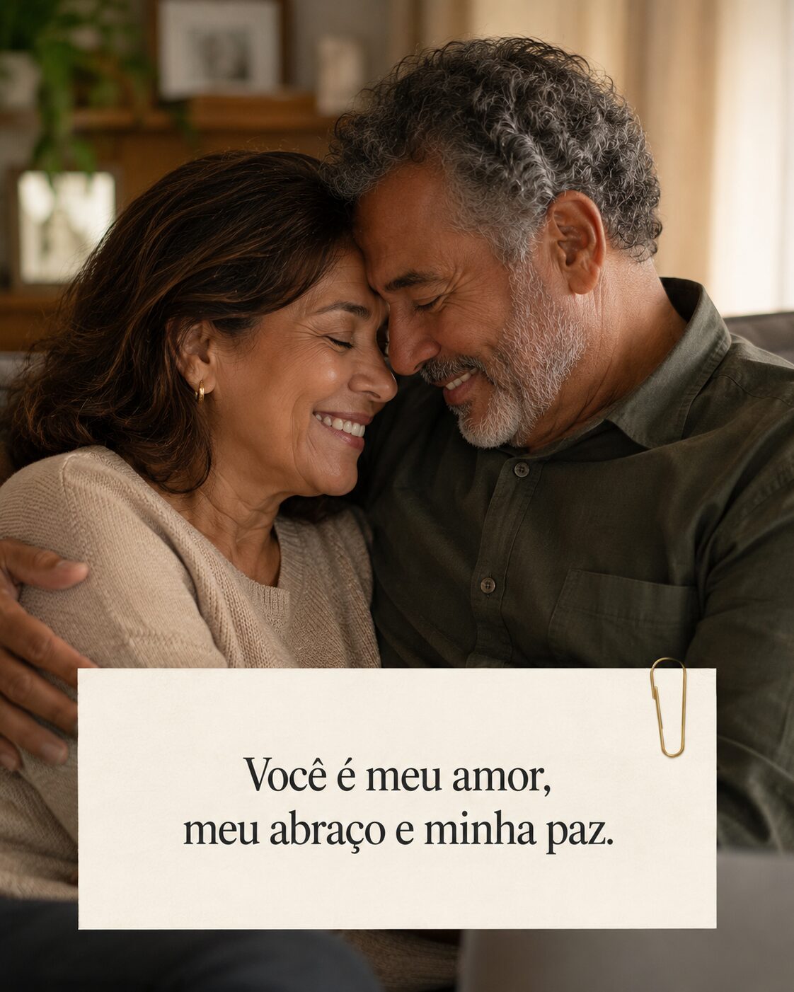 Casal mais velho se abraçando com as testas encostadas, sorrindo em um ambiente doméstico e acolhedor
